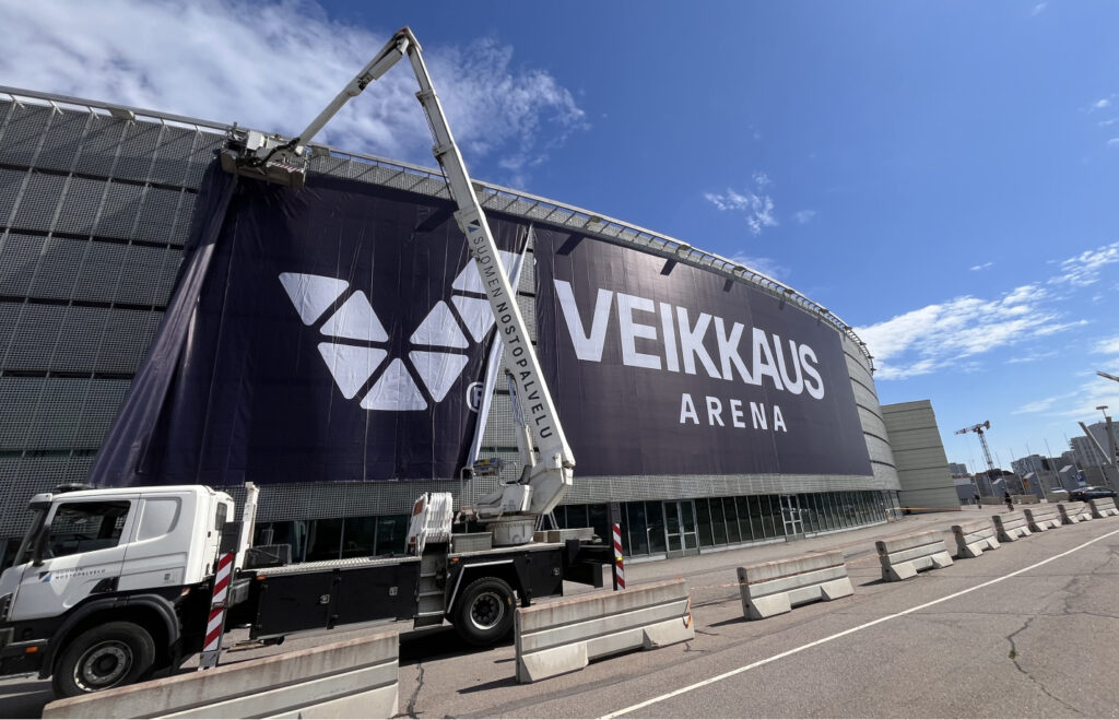 Veikkaus Arena mainosplakaattia asennetaan entisen Helsinki-hallin (Hartwall Areena) seinään.