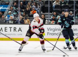 Ottawa Senatorsin Brady Tkachuk kiekkoilee Seattle Krakenia vastaan NHL-ottelussa, taustalla yleisö seuraamassa peliä.