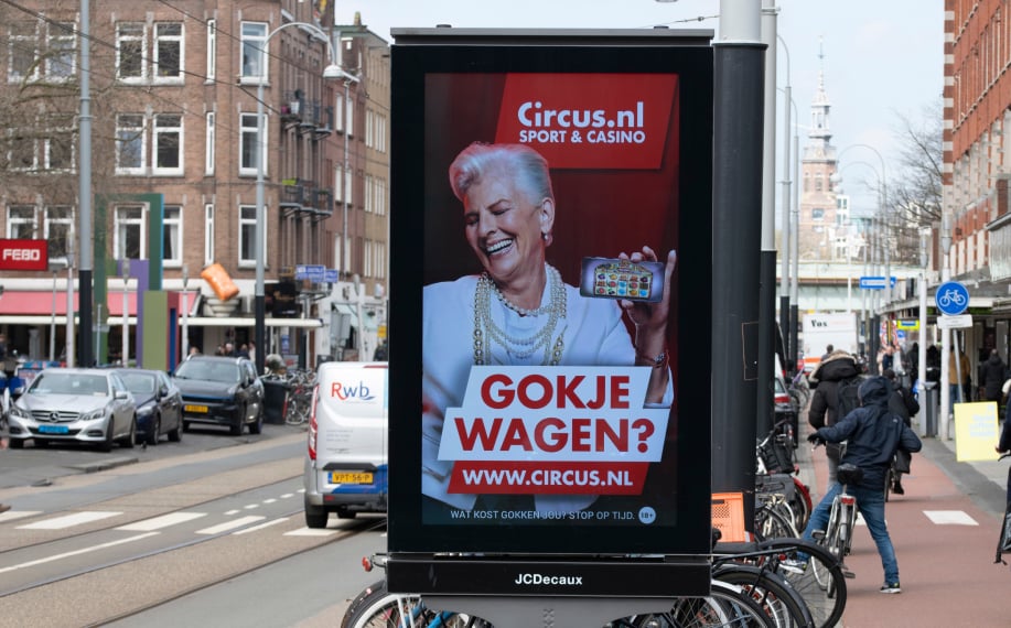 Circus.nl Sport & Casino mainos missä harmaahiuksinen nainen hymyilee hedelmäpelin kanssa.