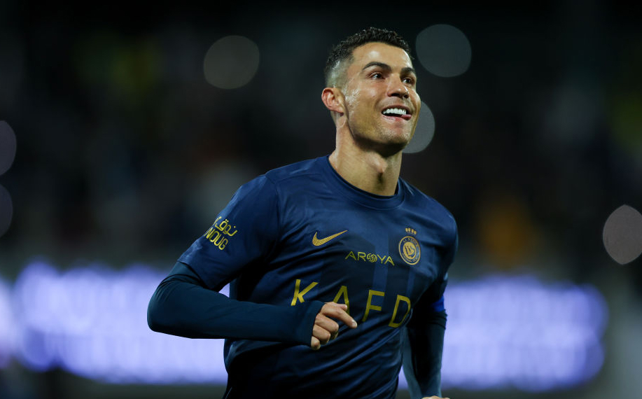 Ronaldo hymyilee Saudi-Arabialaisen jalkapallojoukkueen paidassa.