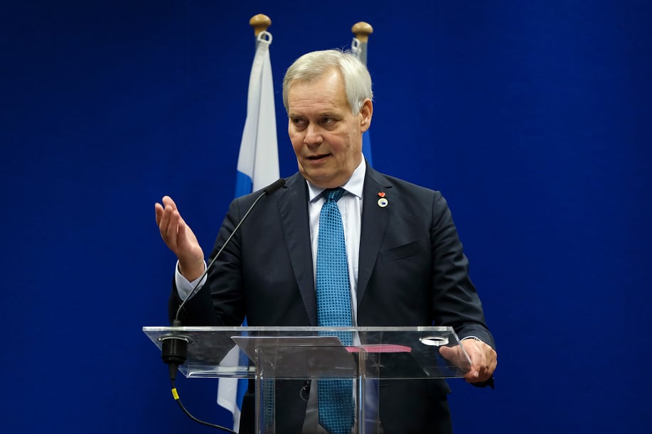 Antti Rinne Suomen ja EU lipun edessä puhujanpöntöllä.