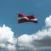 Latvian lippu liehuu taivasta vasten