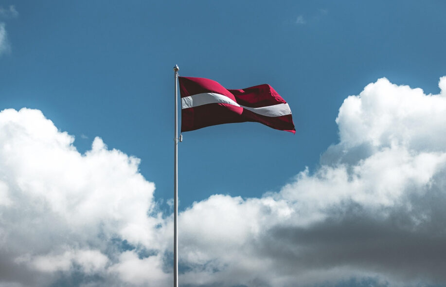 Latvian lippu liehuu taivasta vasten