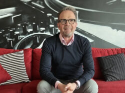 Nummikoski Veikkauksen toimistolla soffalla hymyillen.