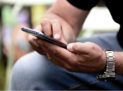 Mies selaa puhelinta.